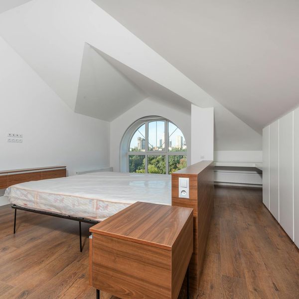 Woman with a calm and focused expression in a softly lit room.